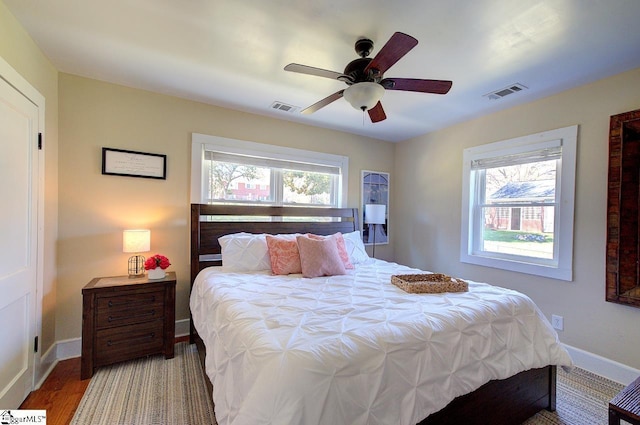 bedroom with multiple windows, visible vents, and baseboards