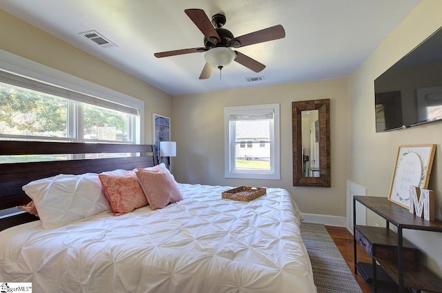 bedroom featuring baseboards, visible vents, and multiple windows