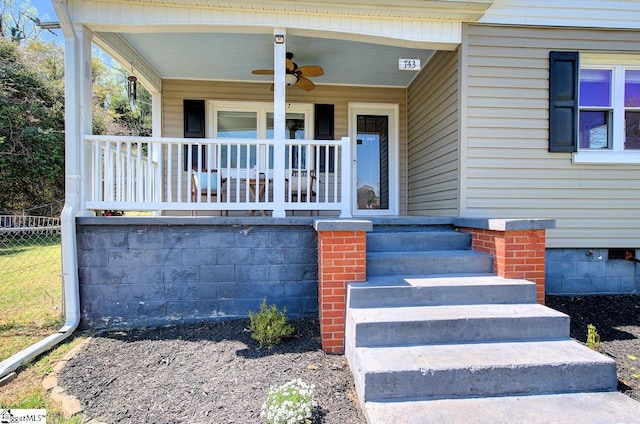 doorway to property with ceiling fan, fence, and a porch