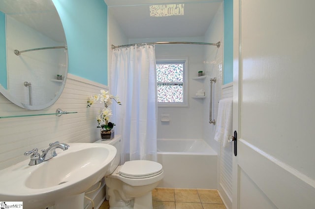 bathroom with tile patterned flooring, tile walls, toilet, a sink, and shower / bath combination with curtain