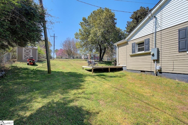 view of yard with an outdoor structure, a storage unit, fence, and a wooden deck