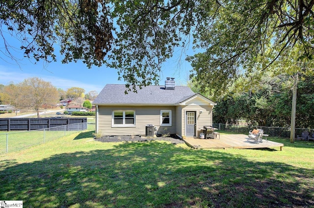 rear view of property featuring a lawn, a chimney, cooling unit, and a deck