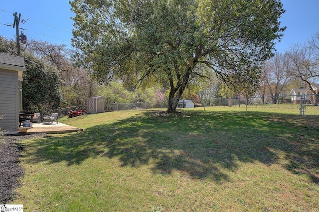 view of yard with a fenced backyard, a storage unit, and an outdoor structure