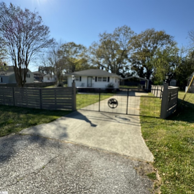view of front of home with a front lawn, a gate, and a fenced front yard