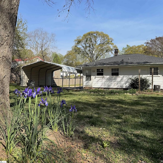 view of yard with central AC unit and a carport