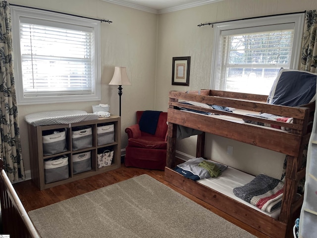 bedroom with multiple windows, wood finished floors, and ornamental molding