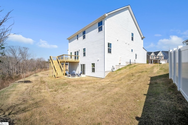 rear view of property with a lawn, a deck, and stairway