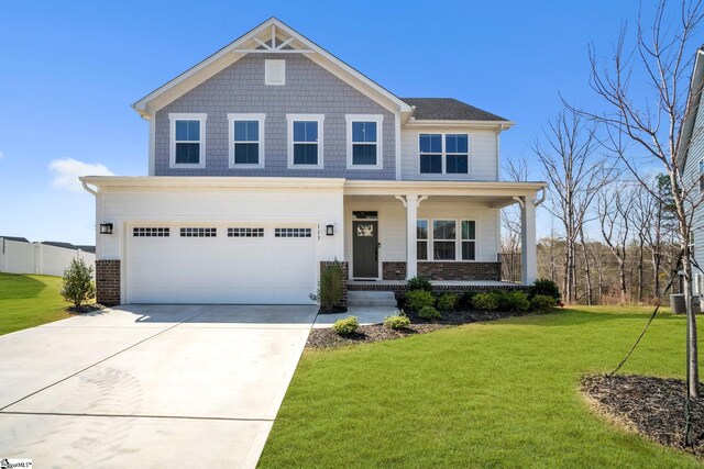 view of front of home with concrete driveway, brick siding, a porch, and a front lawn
