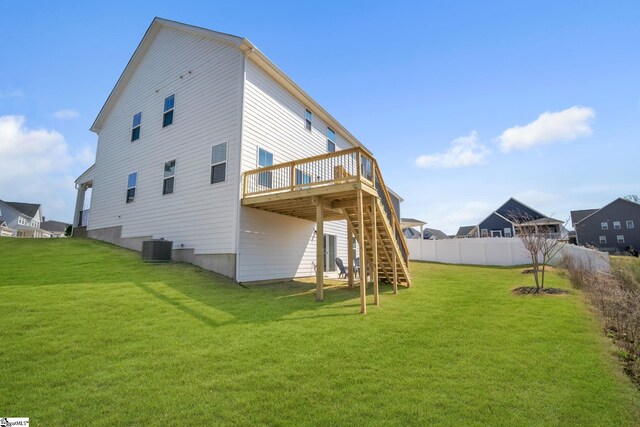 back of property featuring a lawn, a deck, stairway, central air condition unit, and fence