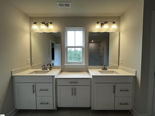 bathroom with visible vents, a sink, tile patterned flooring, and tiled shower