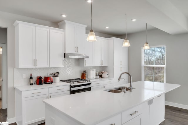 kitchen with decorative backsplash, gas range, dark wood finished floors, a sink, and under cabinet range hood