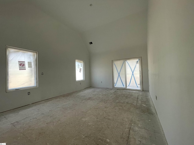 unfurnished room featuring visible vents and high vaulted ceiling