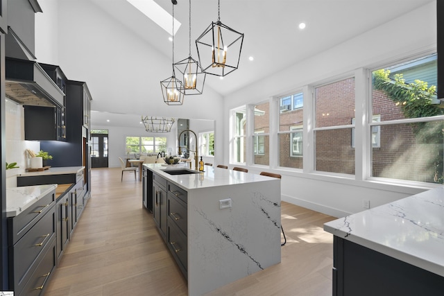 kitchen featuring a sink, an inviting chandelier, black dishwasher, and light wood-type flooring