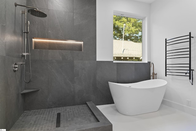 bathroom featuring a freestanding tub, radiator, baseboards, and walk in shower