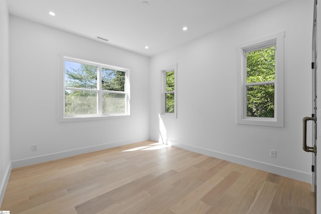 spare room with baseboards, a wealth of natural light, recessed lighting, and light wood-style floors