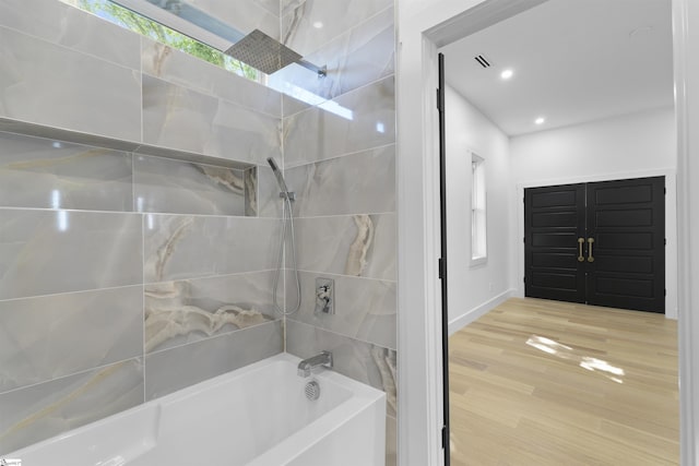 bathroom with tub / shower combination, recessed lighting, baseboards, and wood finished floors