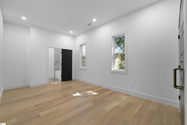 empty room with light wood finished floors, visible vents, and recessed lighting