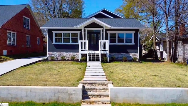 bungalow-style house featuring a front yard and roof with shingles