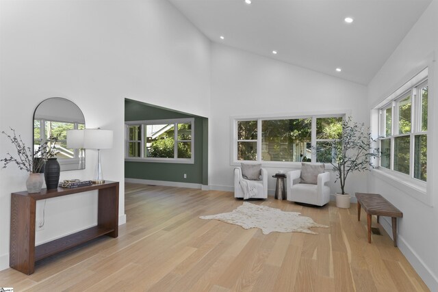 sitting room with baseboards, high vaulted ceiling, wood finished floors, and recessed lighting
