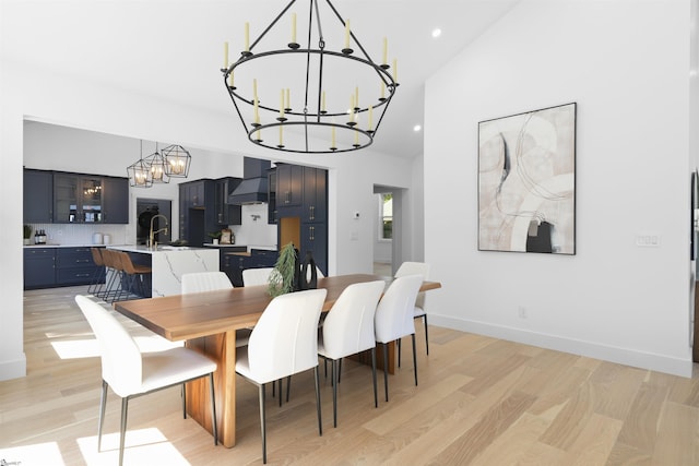 dining space featuring an inviting chandelier, light wood-style flooring, baseboards, and recessed lighting