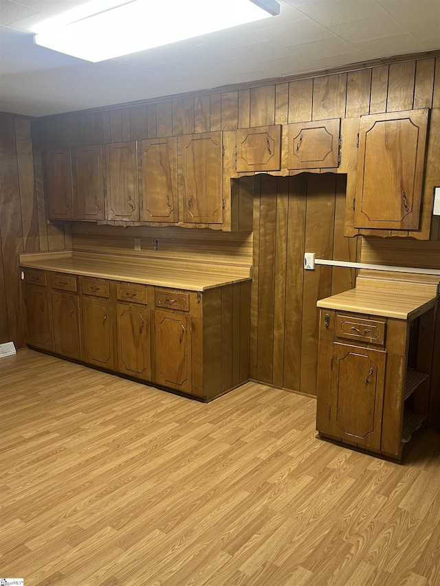 1273 Powerhouse Rd, Ware Shoals, SC 29692 - kitchen with light countertops, wood walls, brown cabinetry, and light wood-type flooring