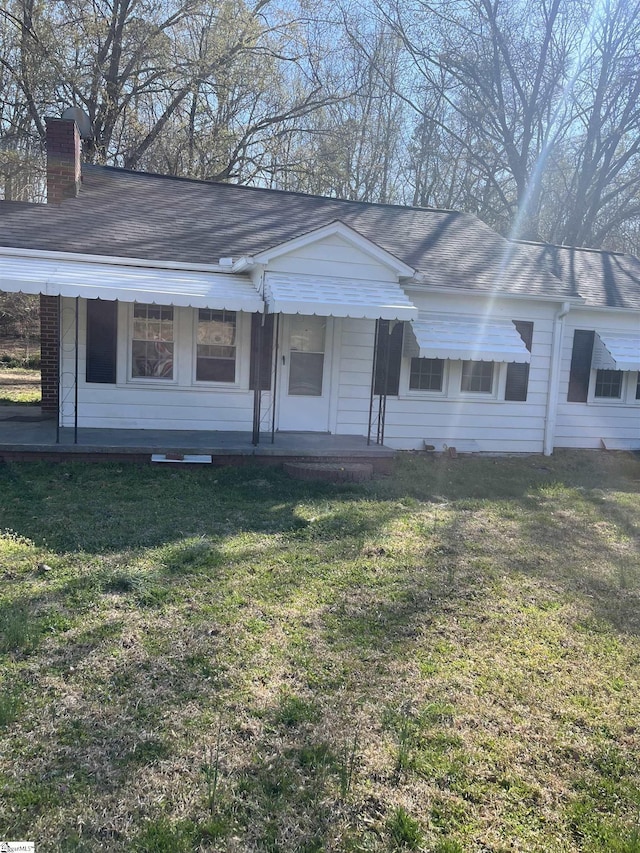 1273 Powerhouse Rd, Ware Shoals, SC 29692 - ranch-style house with a porch, a front yard, roof with shingles, and a chimney