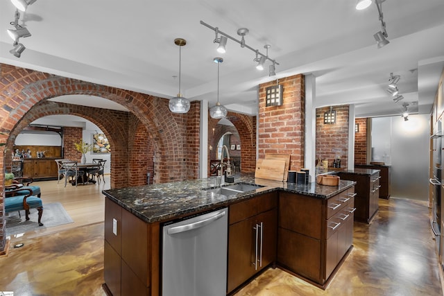 400 E Washington St Unit 28, Greenville, SC 29601 - kitchen featuring stainless steel dishwasher, a sink, arched walkways, brick wall, and an island with sink