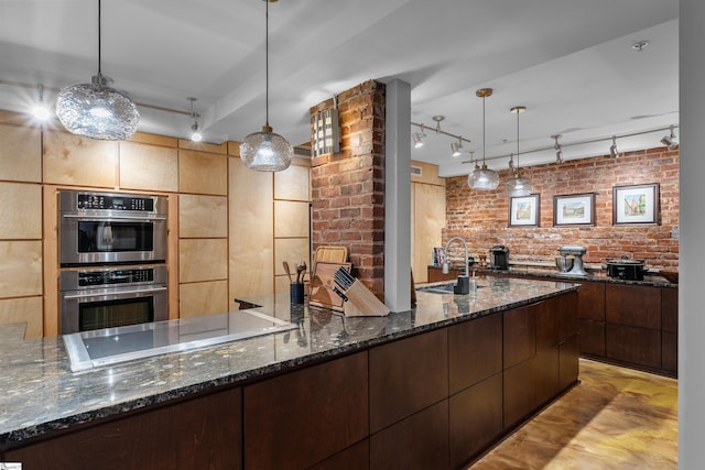 400 E Washington St Unit 28, Greenville, SC 29601 - kitchen featuring black electric cooktop, dark stone countertops, double oven, a sink, and brick wall