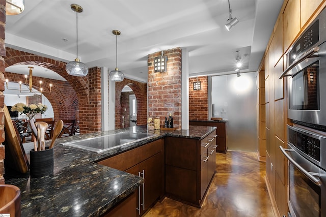 400 E Washington St Unit 28, Greenville, SC 29601 - kitchen with finished concrete flooring, hanging light fixtures, black electric cooktop, brick wall, and arched walkways