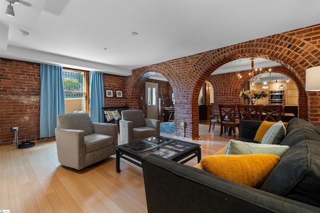 400 E Washington St Unit 28, Greenville, SC 29601 - living room featuring light wood-style flooring, arched walkways, brick wall, and a fireplace