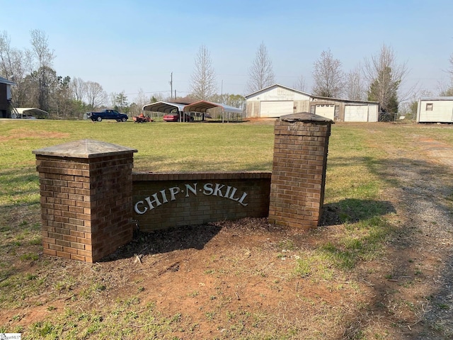 community sign featuring a lawn, a garage, and a carport