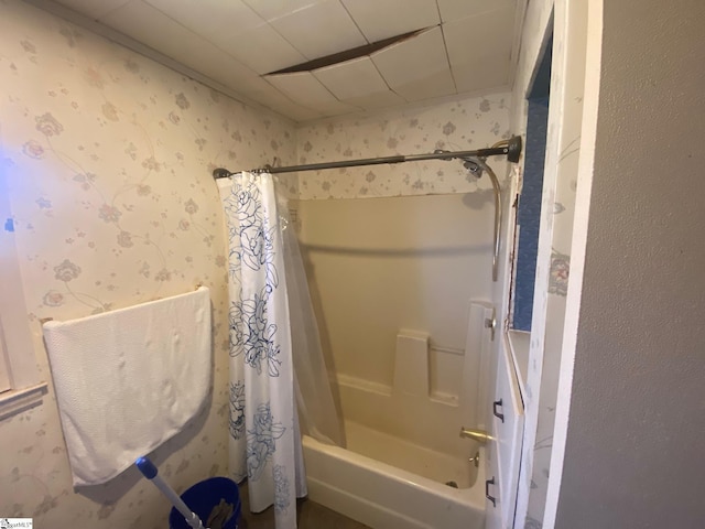 bathroom featuring shower / bath combo and wallpapered walls