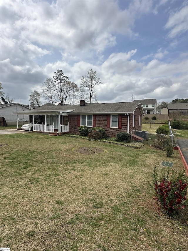 view of front of house with an attached carport, a front yard, a porch, and brick siding