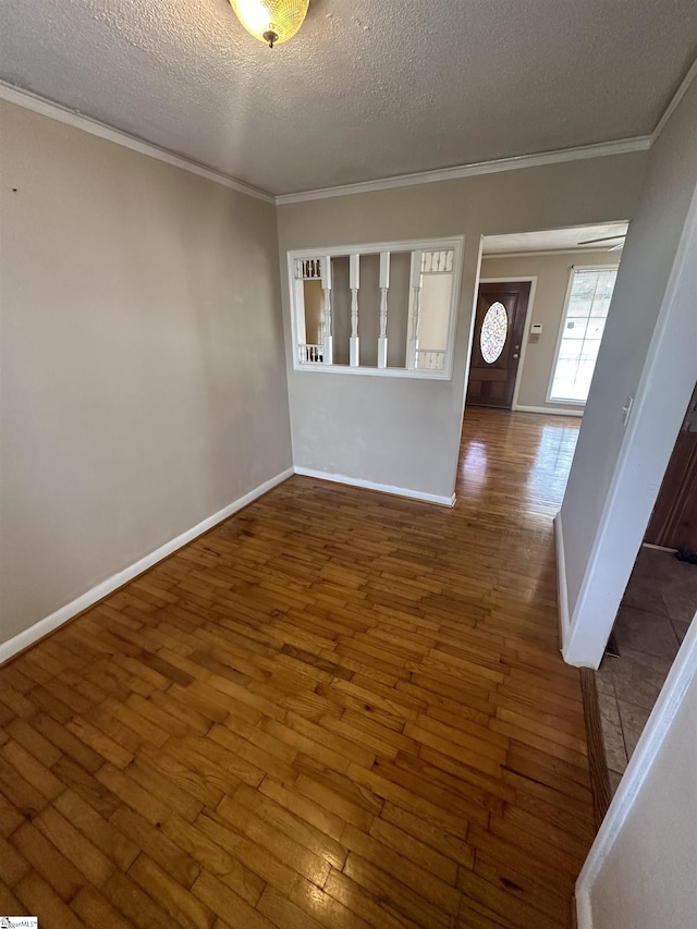 interior space with ornamental molding, hardwood / wood-style flooring, and baseboards