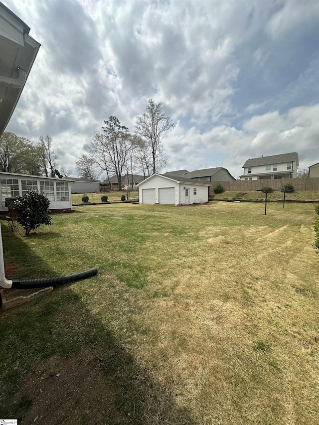 view of yard featuring a garage and fence