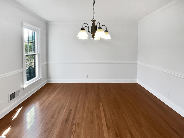 unfurnished dining area featuring baseboards, a notable chandelier, wood finished floors, and ornamental molding