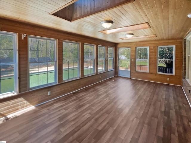 unfurnished sunroom with a wealth of natural light, visible vents, wood finished floors, and wooden ceiling