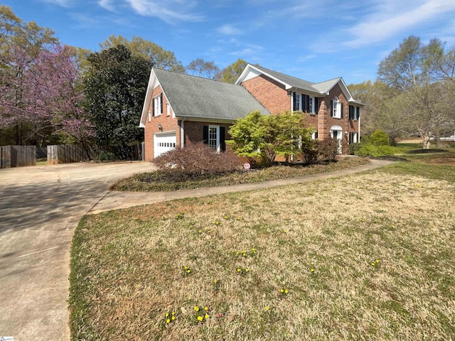 view of property exterior with concrete driveway, fence, brick siding, a garage, and a yard