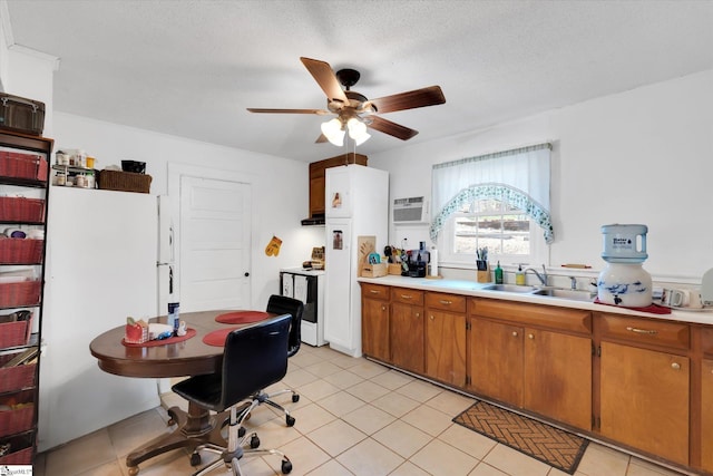 kitchen with light countertops, a sink, brown cabinets, light tile patterned floors, and white appliances