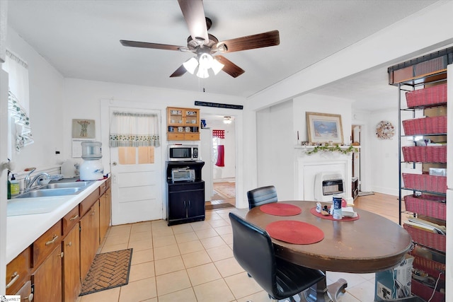 dining space with heating unit, light tile patterned floors, and ceiling fan