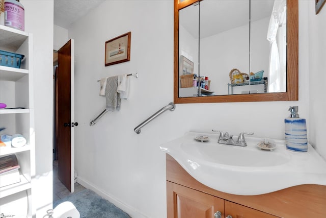 bathroom with baseboards, vanity, and built in shelves