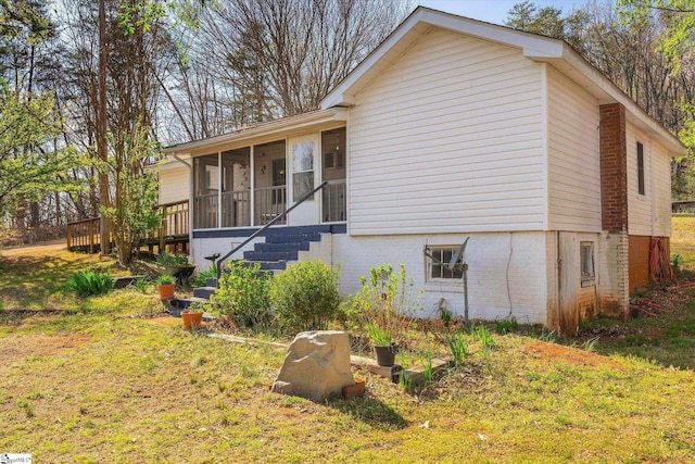 exterior space featuring a sunroom, stairs, and brick siding