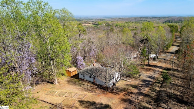 birds eye view of property featuring a forest view
