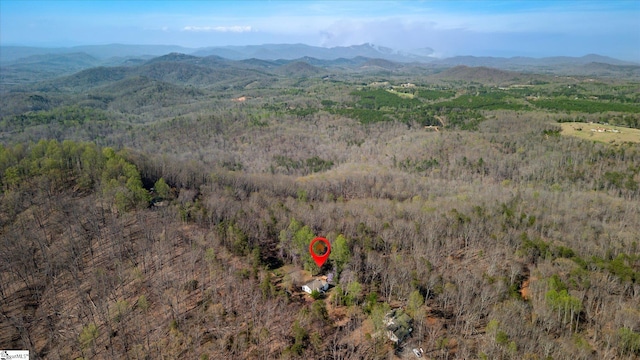 aerial view featuring a wooded view and a mountain view