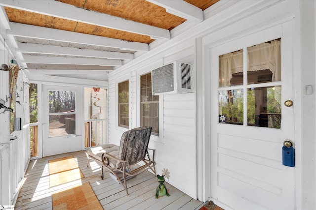 sunroom / solarium featuring beam ceiling and an AC wall unit