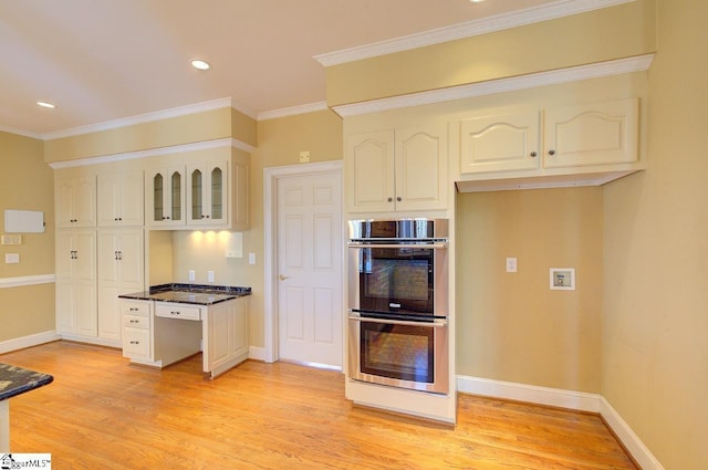 206 Chelsea Ln, Greer, SC 29650 - kitchen with stainless steel double oven, ornamental molding, baseboards, dark countertops, and light wood-style floors