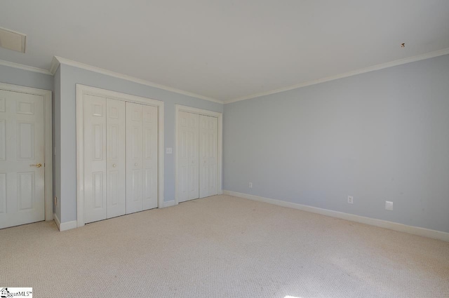206 Chelsea Ln, Greer, SC 29650 - unfurnished bedroom with ornamental molding, light carpet, baseboards, and multiple closets