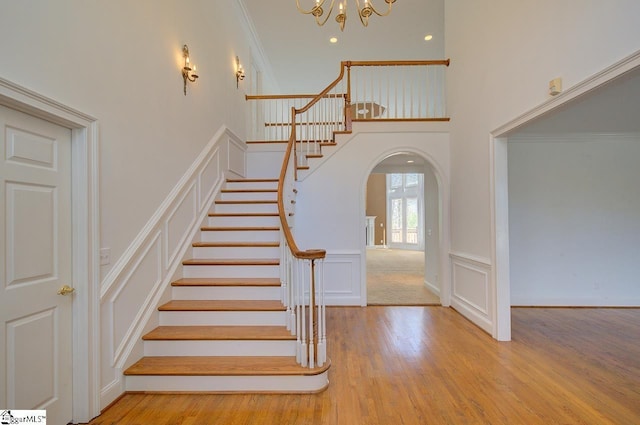 206 Chelsea Ln, Greer, SC 29650 - stairs with an inviting chandelier, ornamental molding, arched walkways, a decorative wall, and wood finished floors