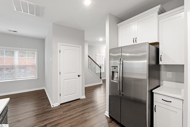 kitchen featuring white cabinetry, visible vents, and stainless steel fridge