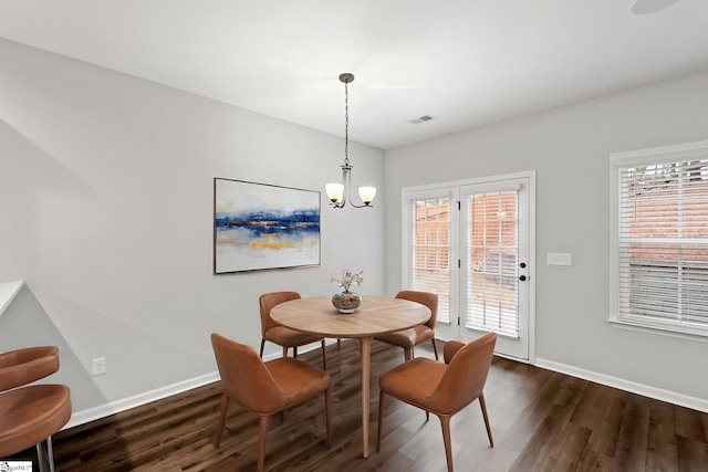 dining area featuring dark wood finished floors, plenty of natural light, and visible vents